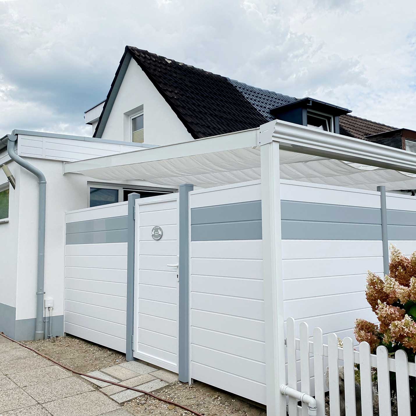 Sichtschutzzaun  aus Kunststoff PVC in Weiß und Grau für eine überdachte Terrasse