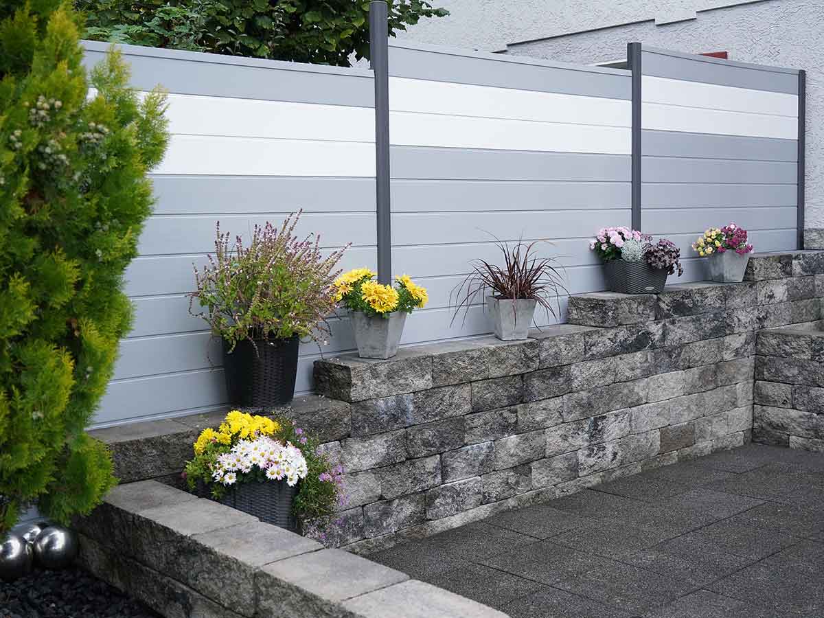Sichtschutz aus Kunststoff auf der Terrasse in Grau mit weißen Akzenten und Aluminium Steckpfosten in Anthrazit