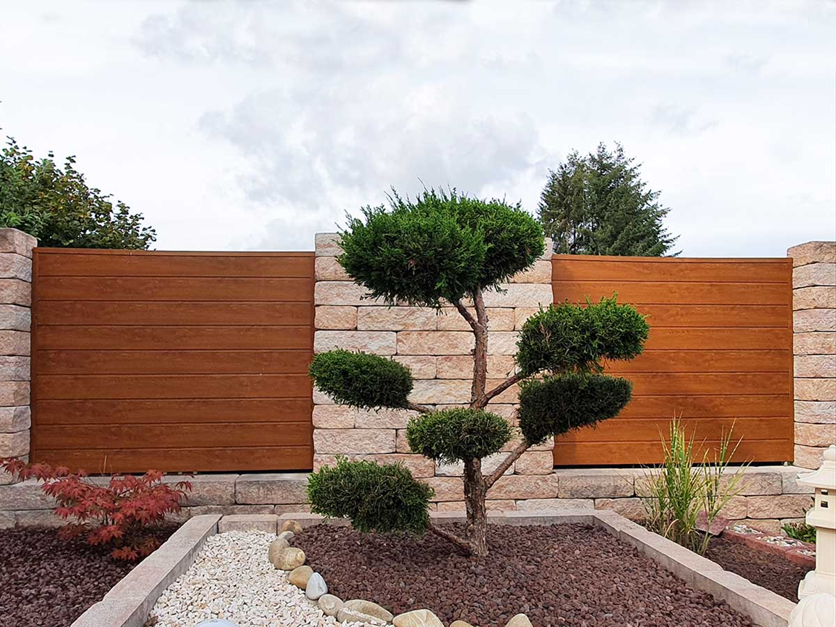 Sichtschutz aus Kunststoff PVC in Holzoptik Golden Oak zwischen Mauern Steinsäulen im Garten